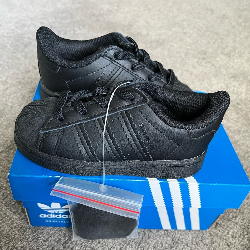 All black adidas superstar.